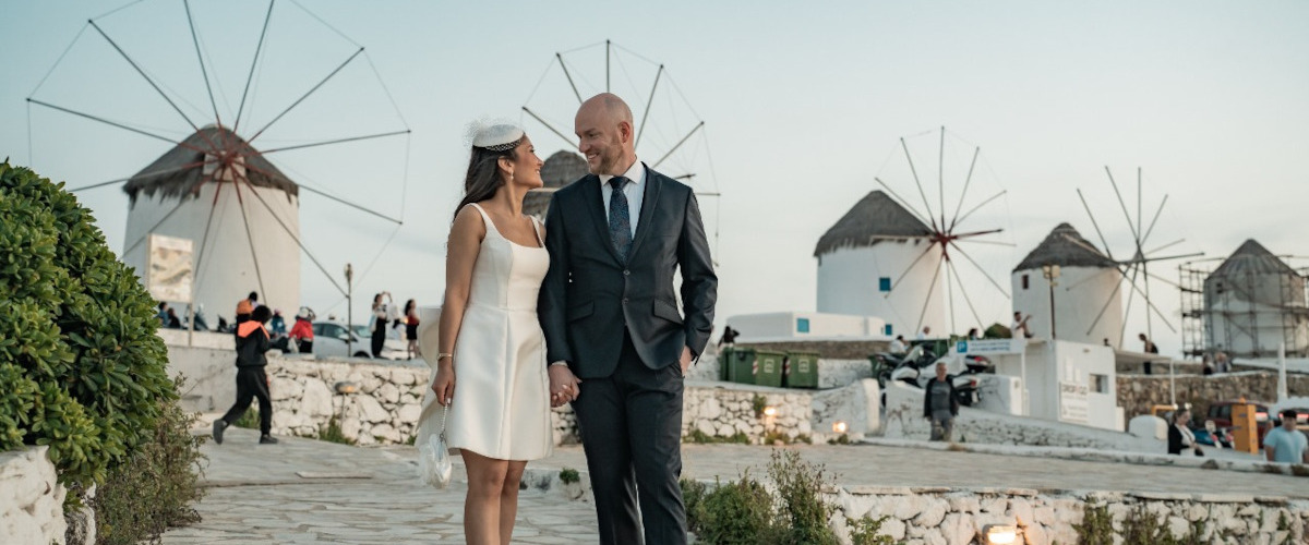 Enchanting Mykonos wedding photograpjhy of a couple at the windmills, showcasing the beauty of love through exquisite photography and videograph